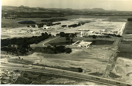 Vista do prédio do refeitório e lago-reservatório durante a contrução da Refinaria Alberto Pasqualini (REFAP)