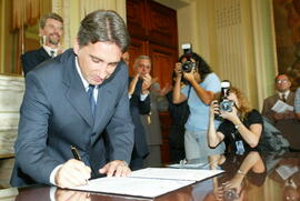 Germano Rigotto assina o decreto de devolução do Colégio Tiradentes para a Brigada Militar. Autor: Nabor Goulart